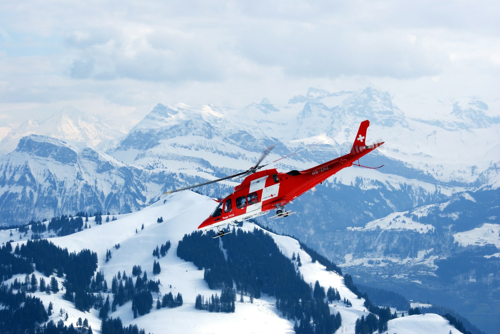 photo dights of red and white rescue helicopter during snow daytime